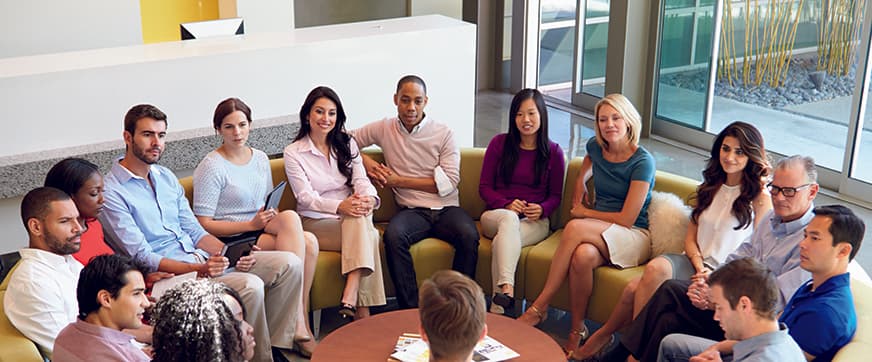Multi-Cultural Office Staff Sitting Having Meeting Together