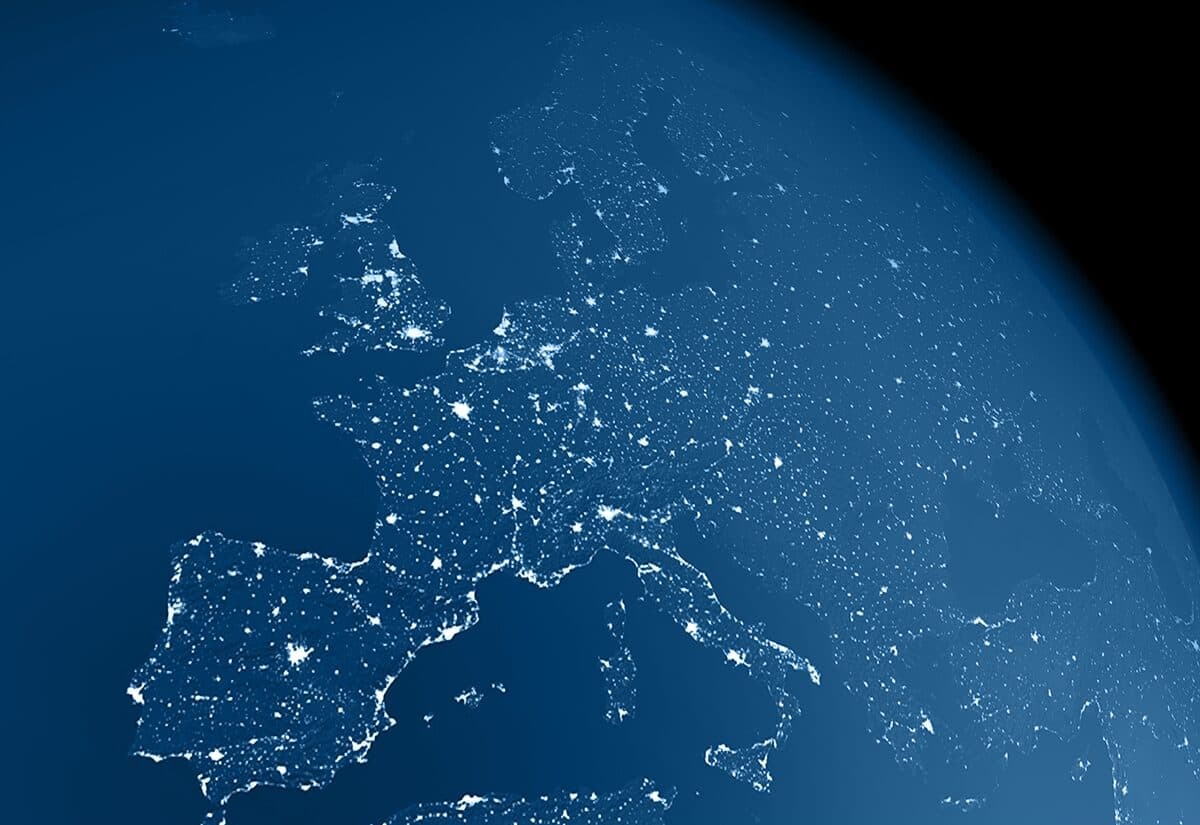A realistic image of the earth from space at night with light emissions from large urban areas and atmospheric haze. The center of the view is Europe. The image is a rendered 3d scene.