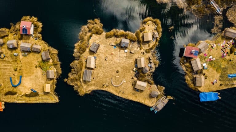 Aerial top view photo of floating islands on Lake Titicaca in Peru – a habitant of indigenous community Uros who are living on floating self-made islands made of totora plant