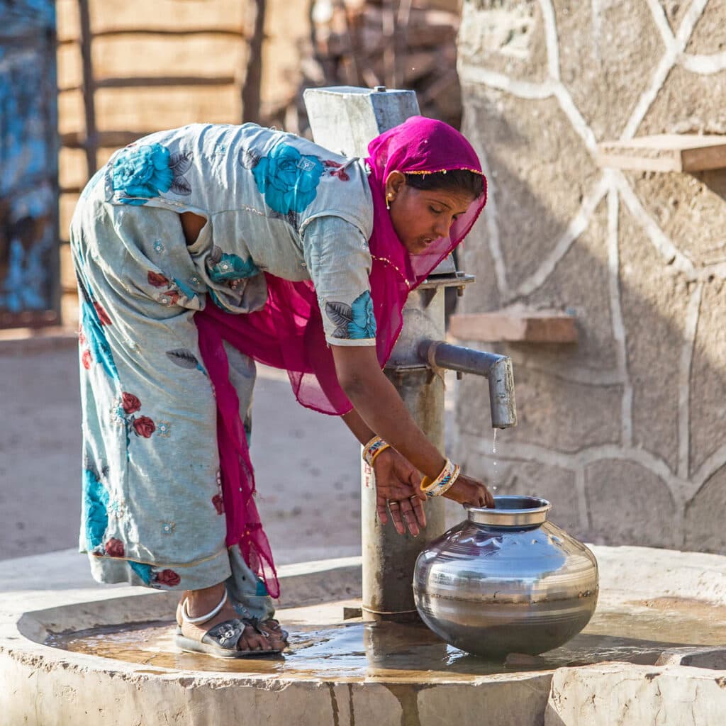 Rabari tribe woman pumping water from a communal well, Jojawar, India.