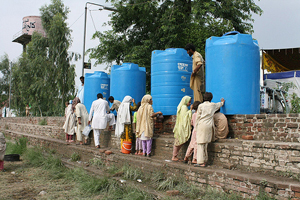 People collect water from Oxfam tanks in Nowshera