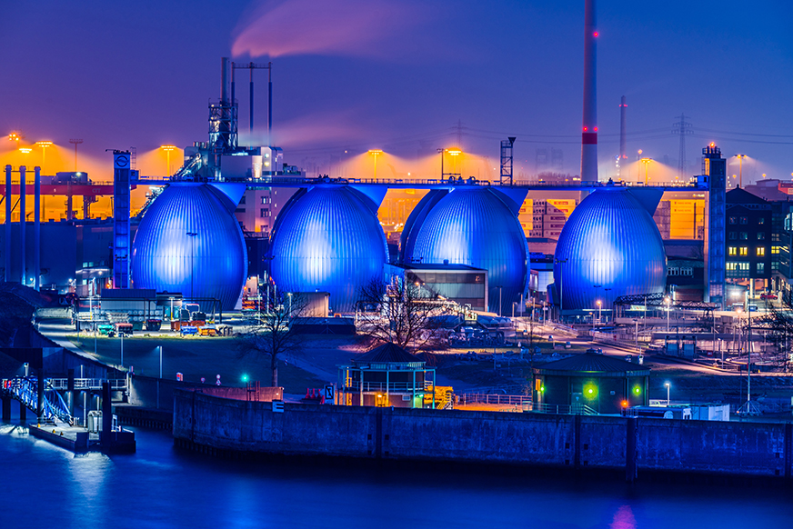 Digestion towers, wastewater treatment plant, Hamburg, Germany, at night.