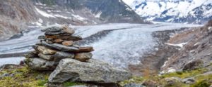 Stunning view of Aletsch glacier, the largest glacier in the European Alps, located in the Bernese Alps in Switzerland. A Stoneman (rock cairn) in the foreground. Selective focus.