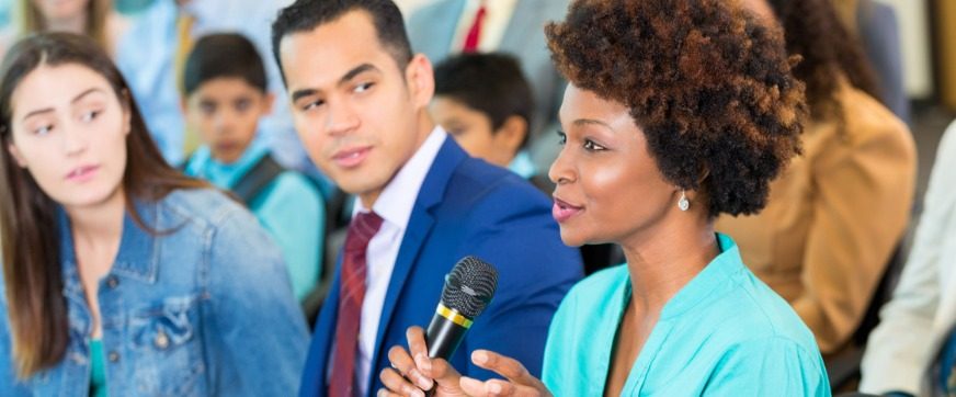 confident-african-american-woman-asks-question-during-a-meeting-picture-id607460110