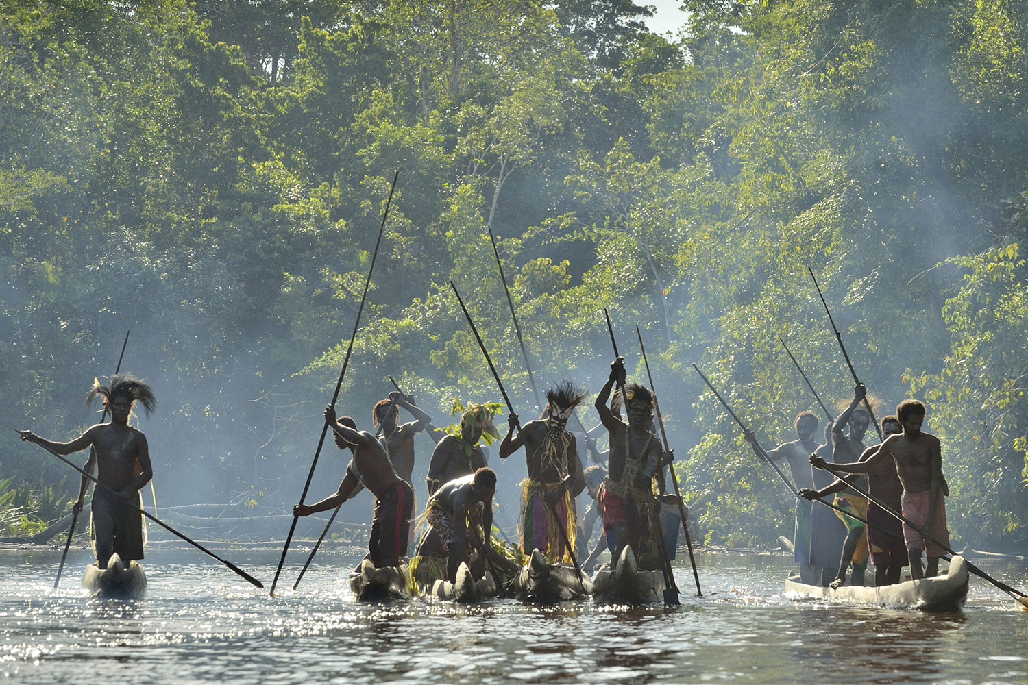 Asmat warriors paddling through the jungle in Papua New Guinea.