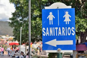 Blue sign of public lavatory with arrow mark in the Historic World Heritage Site of Guanajuato., Mexico. Photo: Takamex