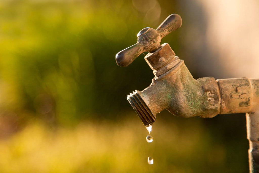 Exterior old water faucet dripping