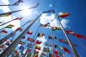 International flags flying against a blue sky.