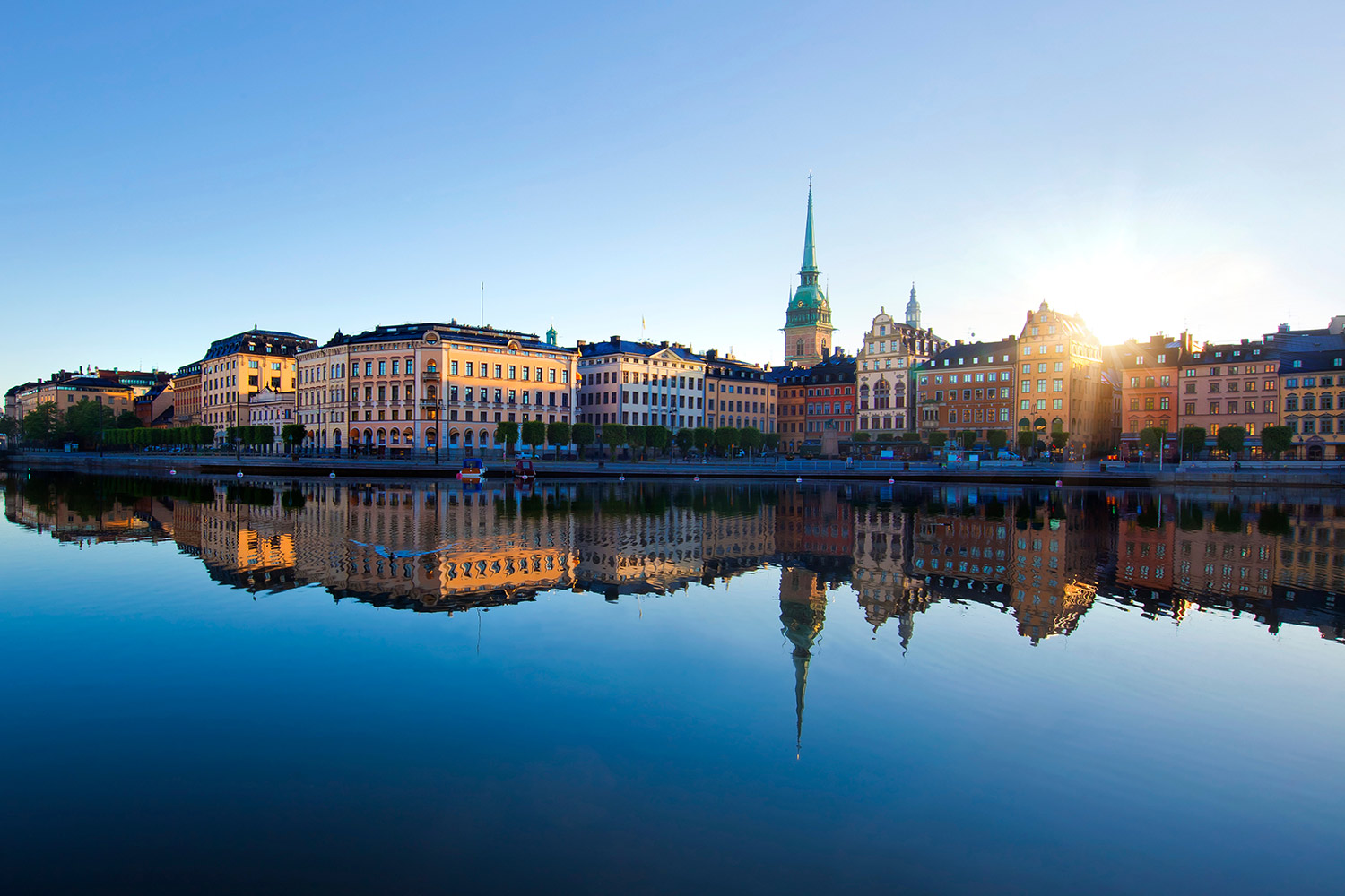 Stockholm's beautiful Old Town at sunrise, reflected in the Riddarfjärden waters.