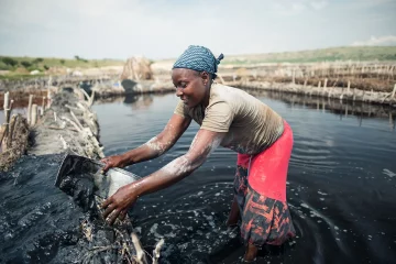 Katwe / Uganda - October 25, 2016: African woman working in the salt mining industry in a salty lake