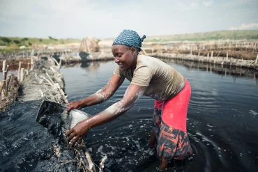 Katwe / Uganda - October 25, 2016: African woman working in the salt mining industry in a salty lake