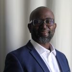 Man with blue suit, white shirt and glasses