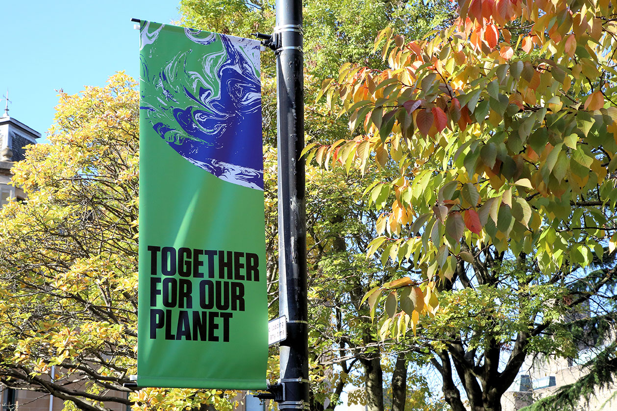 UN Climate Change Conference COP26 Banner in a Glasgow street with the words Together for Our Planet, with a tree in leaf behind it.
