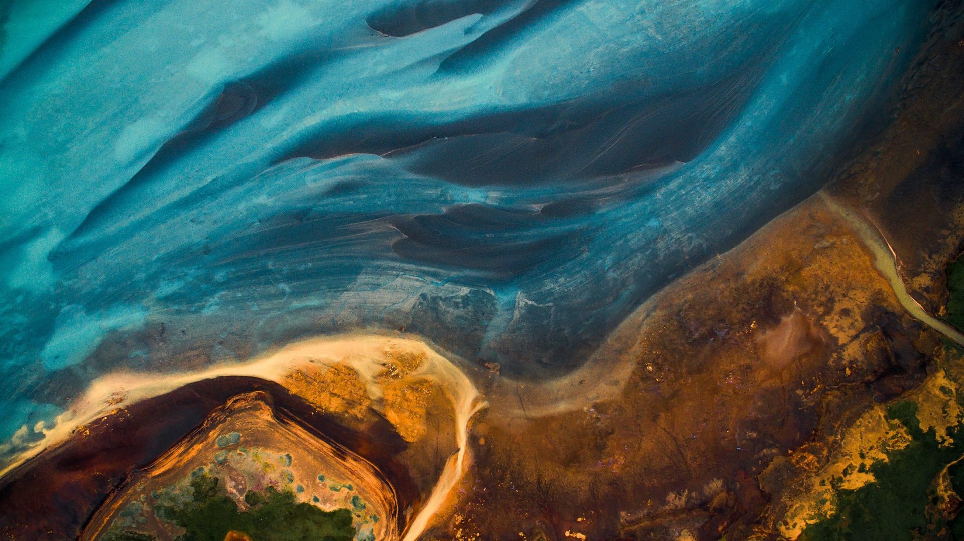 Aerial view from above on a green and blue glacier river stream in South Iceland