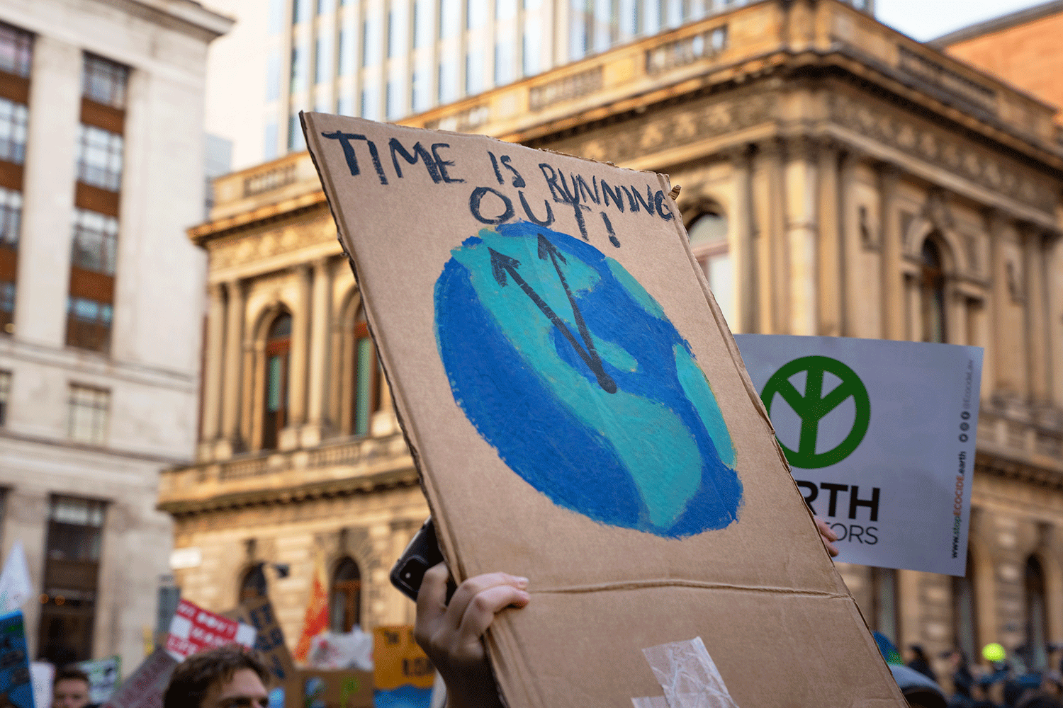 A sign saying 'Time Is Running Out' showing a clock in shape of Earth ticking - at COP26 Youth march in Glasgow, UK, 6 November 2021