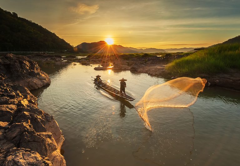 Fisherman of Mekong river in action when fishing of sunrise