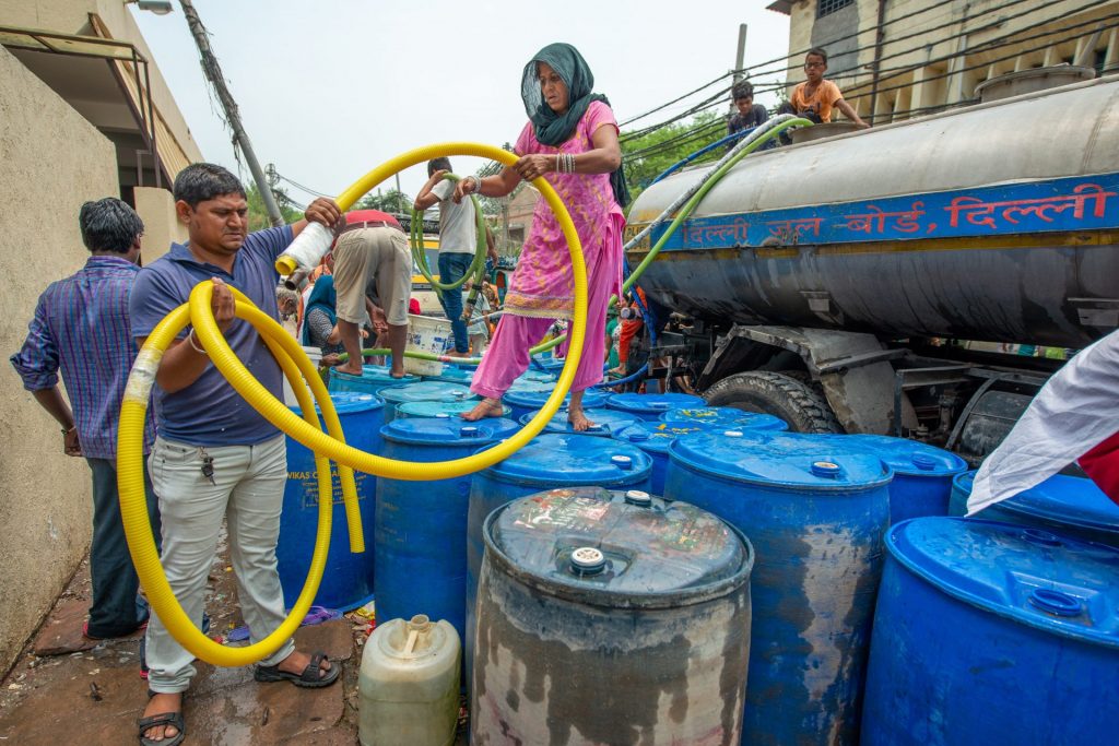 Watertank with multiple hoses distributed in water drums in New Delhi, India