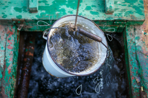 Clean and clear rainwater in a bucket is raised from a well (ovbelov / Shutterstock)