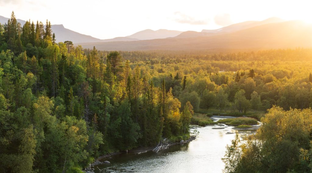 The sun setting over a river in a mountain wilderness. Jamtland, Sweden