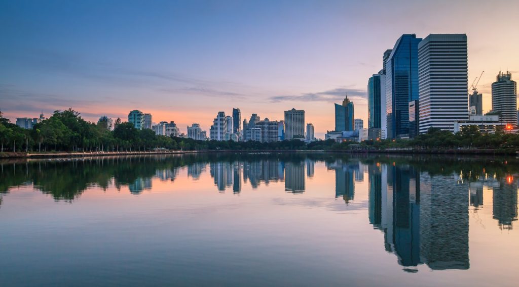 landscape abstract city blur background and The light of sun reflection building on water.Panoramic and perspective wide angle skyscraper commercial modern city of future