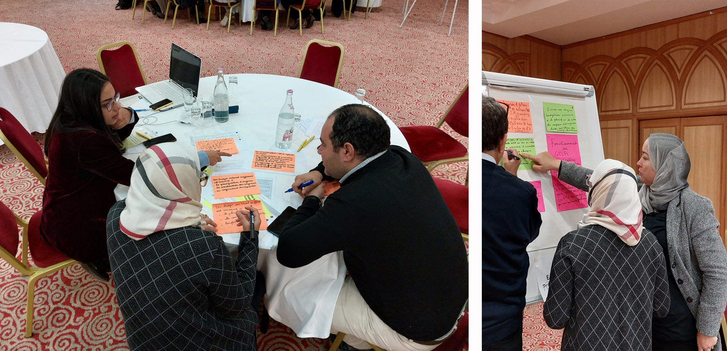 Attendees of the Tunisian WASH BAT workshop sitting round a table and flipchart, with coloured post-it notes