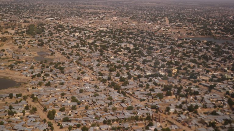 Aerial view of dry landscape with settlements and sparse vegetation.