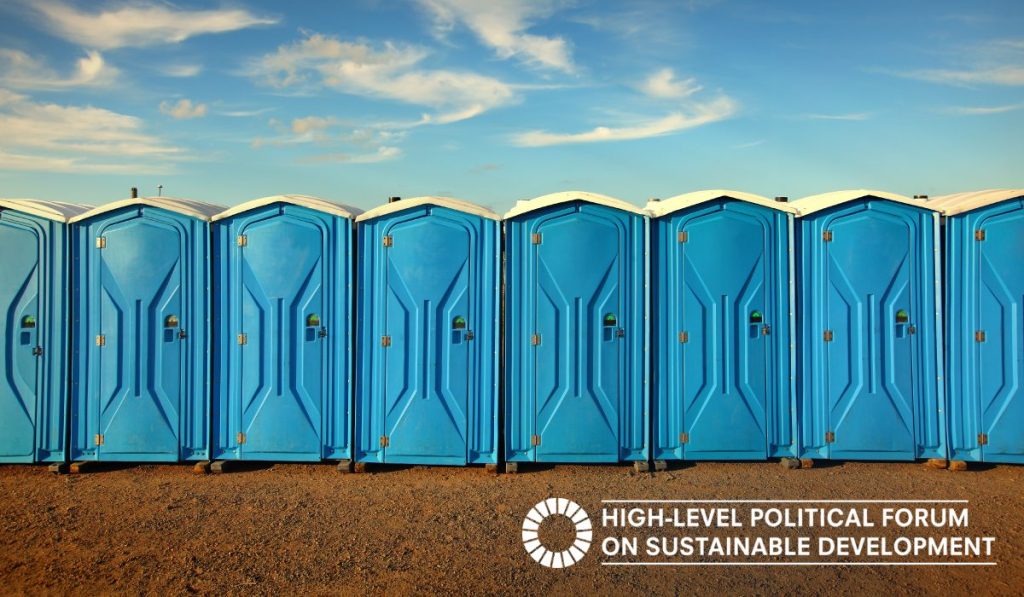 Blue toilet cabins aligned on an orange dirt soil