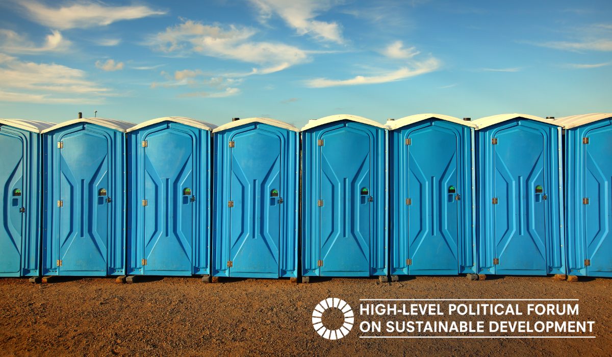 Blue toilet cabins aligned on an orange dirt soil