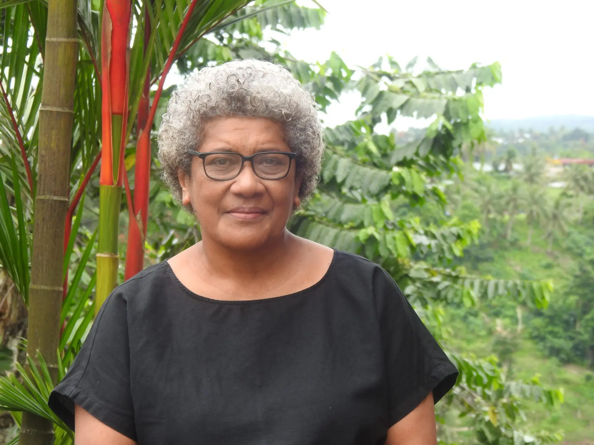 Dr. Milika Sobey, representative of the iTaukei people from Fiji. Stands in front of luxurious green
