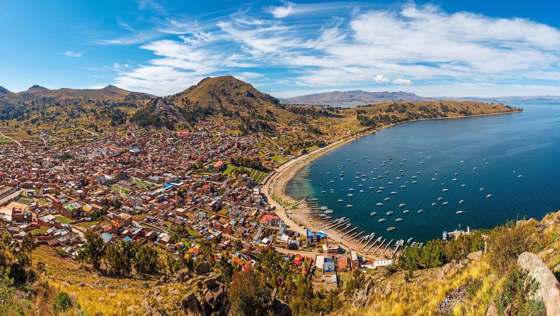 Panoramic image of magnificent lake Titicaca with houses lined up on the coast.