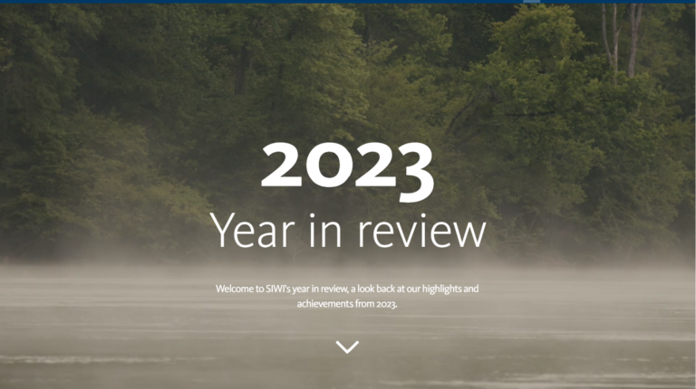 White text "2023 year in review" over a picture of a hazy river with forest in the background