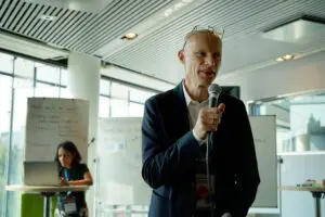 Henk Ovink talking into a microphone. SIWI's Radhika Gupta in the background preparing the interview