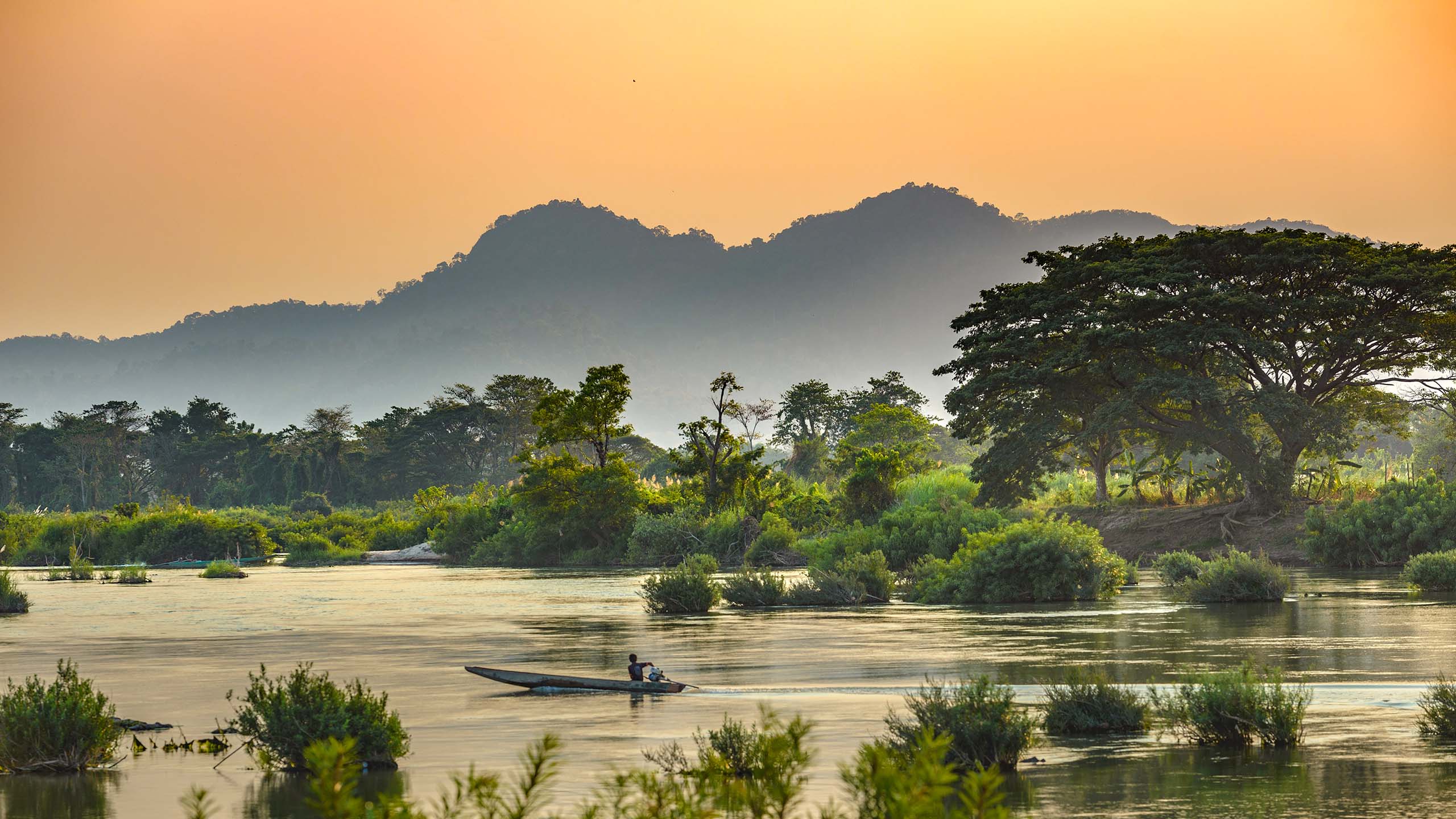 Mekong River 4000 islands Laos, sunrise dramatic sky, mist fog on water, famous travel destination backpacker in South East Asia